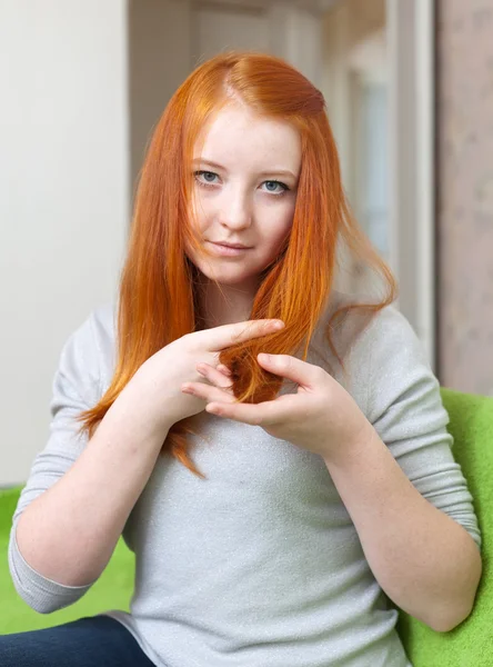 Menina olha para as pontas de seu cabelo — Fotografia de Stock