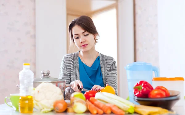 Mujer joven cocina comida vegetariana —  Fotos de Stock