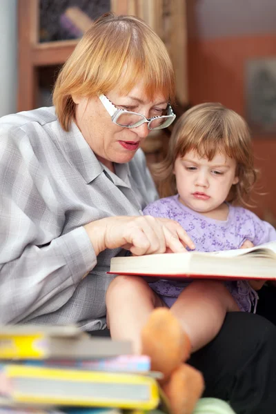 Grootmoeder en kind leest boek — Stockfoto