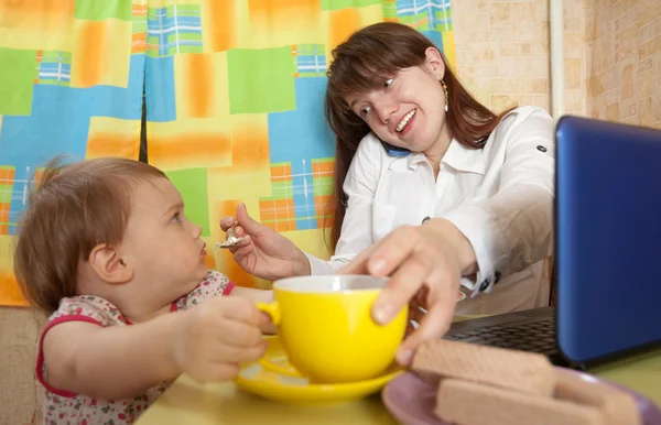 Geschäftsfrau füttert Baby und spricht per Handy — Stockfoto