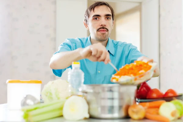 Homem cozinha legumes sagacidade almoço — Fotografia de Stock