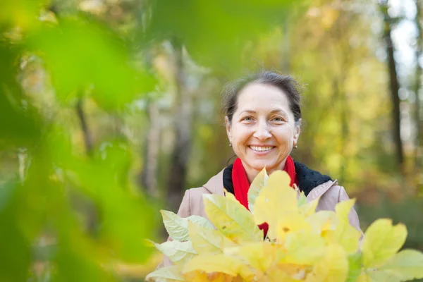 Volwassen vrouw in herfst park — Stockfoto