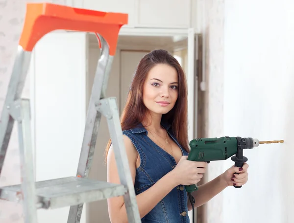Beautiful woman in overalls with drill — Stock Image Beautiful woman in overalls with drill Stock Picture