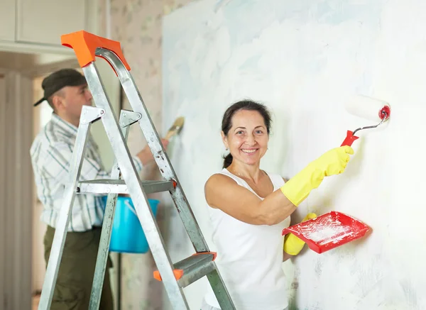 Smiling mature woman and man making repairs — Stock Photo, Image