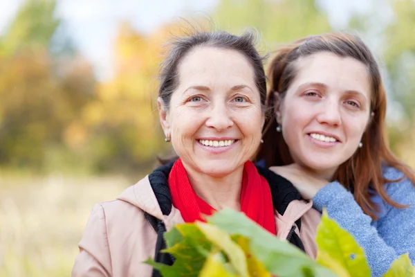 Glada kvinnor i höst trädgård — Stockfoto