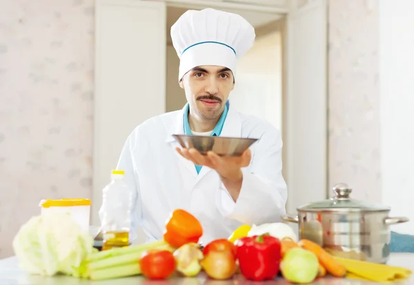 Caucasian cook in uniform with plate — Stock Photo, Image