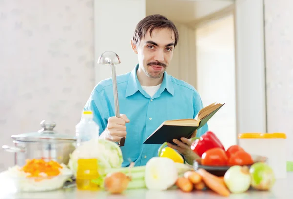 Retrato de homem panela concha e livro de receitas — Fotografia de Stock