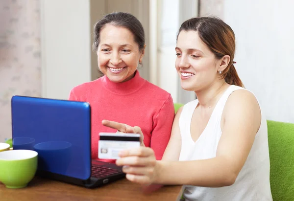 Daughter helps the mother buying online with laptop — Stock Photo, Image