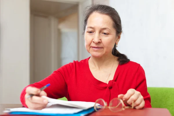 Volwassen vrouw leest documenten — Stockfoto