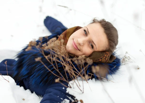 Femme couchée en manteau sur la neige — Photo