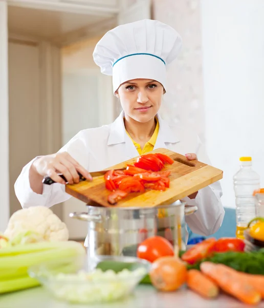 Vrouwelijke cook in toque werken op commerciële keuken — Stockfoto