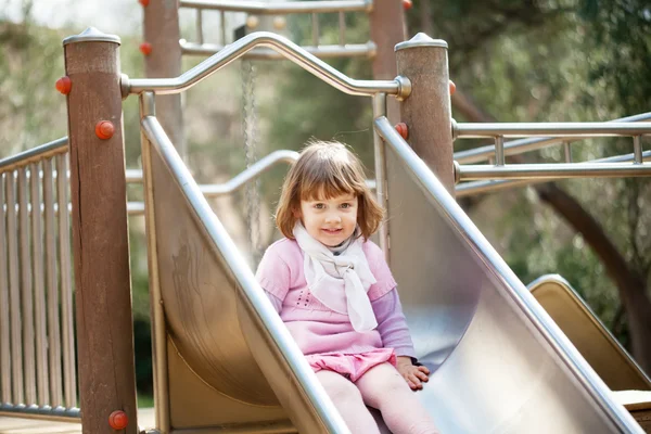 Bébé fille sur toboggan à aire de jeux — Photo