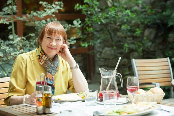 Mogen kvinna med lunch i restaurangen utomhus — Stockfoto