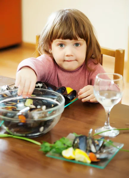 Child eats mussels in home — Stock Photo, Image