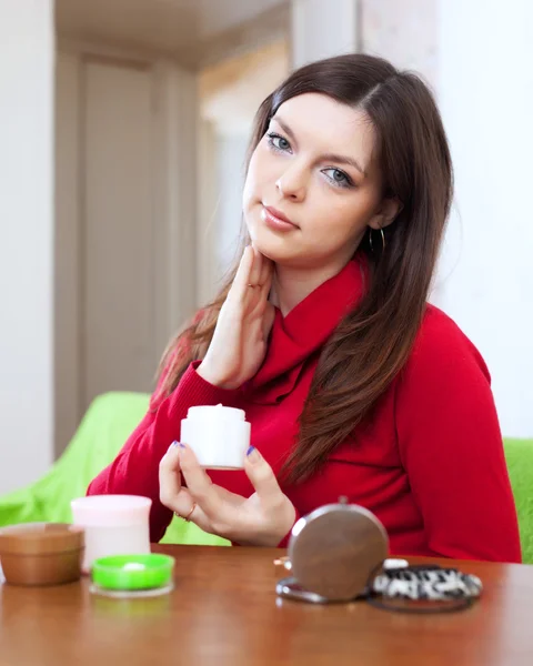 Mujer pone crema en la cara — Foto de Stock