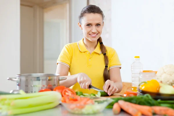 Woman in yellow chopping vegetables — Stock Photo, Image