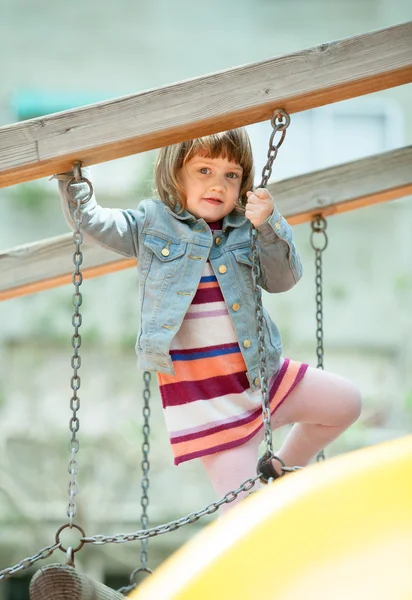 Meisje in jas op speelplaats — Stockfoto