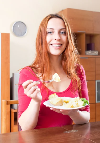 Kobieta w czerwieni jedzenie ziemniaków — Zdjęcie stockowe