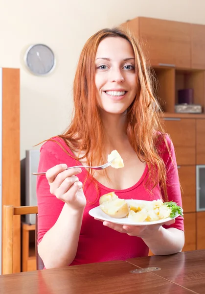 Femme en rouge mangeant des pommes de terre — Photo