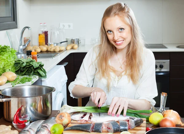 Happy woman cutting seabass — Stock Photo, Image