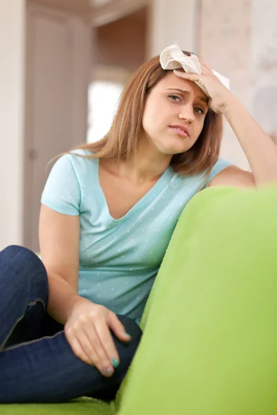 Suffering woman stupes towel to head — Stock Photo, Image