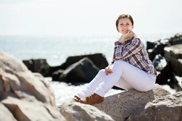 Mujer en piedra en la costa del mar —  Fotos de Stock