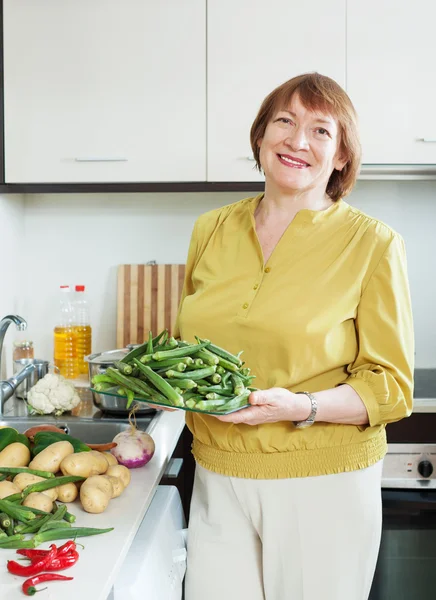 Lachende vrouw koken groenten met okra — Stockfoto