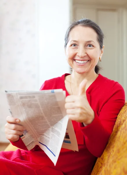Vrolijke volwassen vrouw met krant — Stockfoto