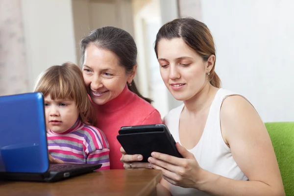 Family of three generations looks devices — Stock Photo, Image