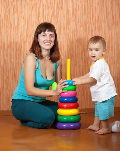 Happy mother and baby plays with pyramidion — Stock Photo, Image