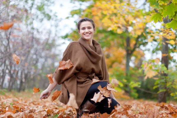 Girl throws maple leaves