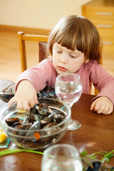 Two-years child eats mussels — Stock Photo, Image
