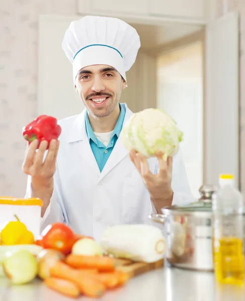 Happy cook man in toque with vegetables — Stock Photo, Image