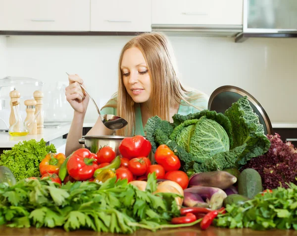 Woman cooking with heap of raw vegetables — Stock Photo, Image