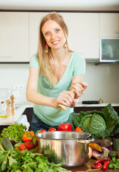 Long-haired woman adding spices — Stock Photo, Image