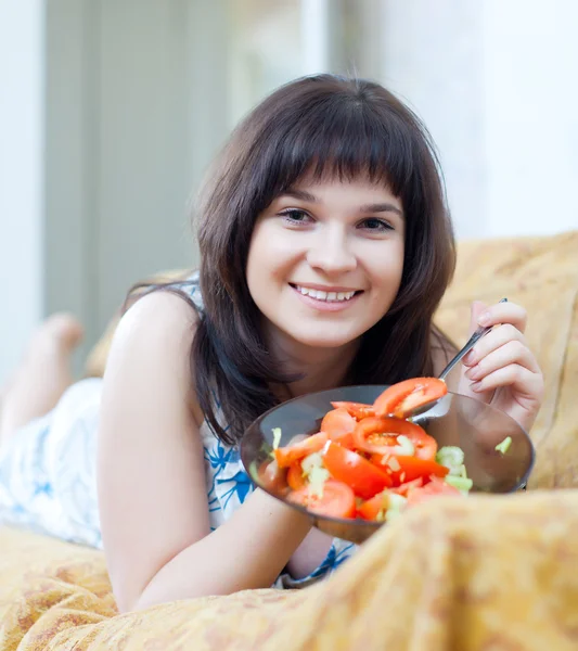 Positive casual woman eats tomatoes salad — Stock Photo, Image