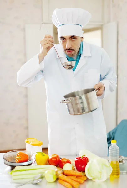 Cozinhar homem degustação sopa de panela — Fotografia de Stock