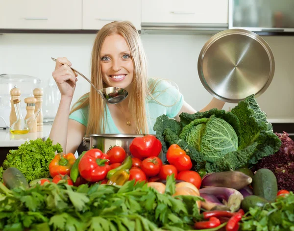 Blonde femme au foyer cuisine avec des légumes frais — Photo