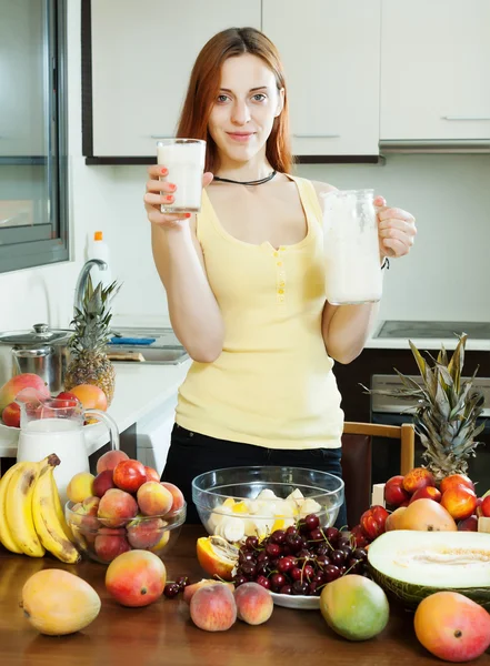 Cheerful housewife drinking milk cocktail with fruits — Stock Photo, Image