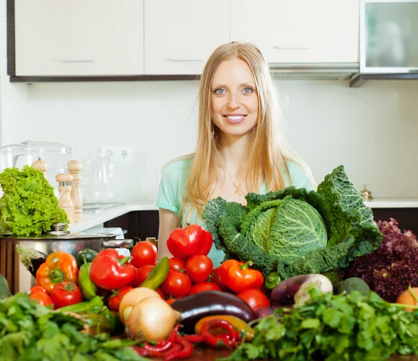 Happy woman with pile of raw vegetables — Stock Photo, Image