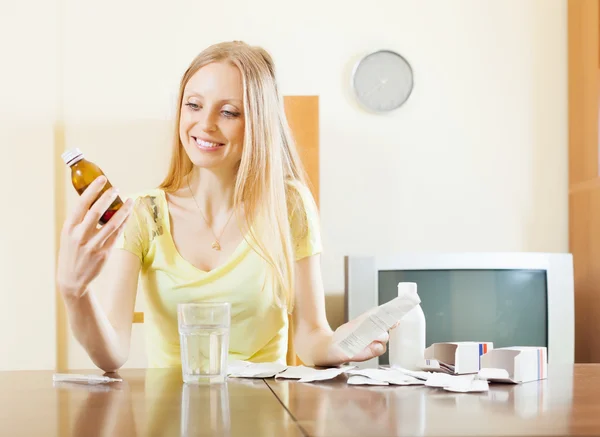 Mulher com medicamentos à mesa — Fotografia de Stock