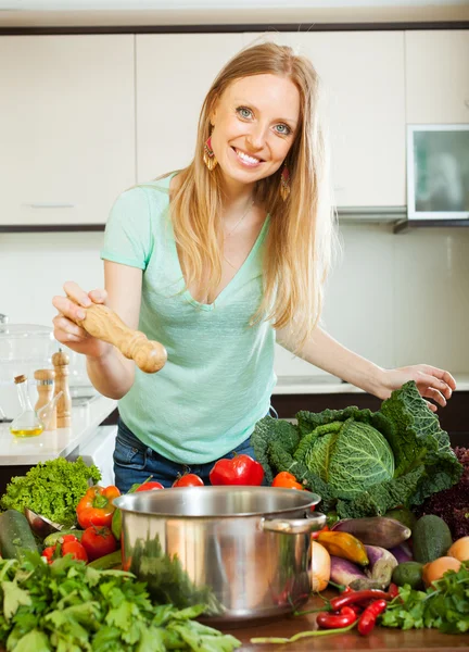 Woman adding spices or salt to the pot — Stock Photo, Image