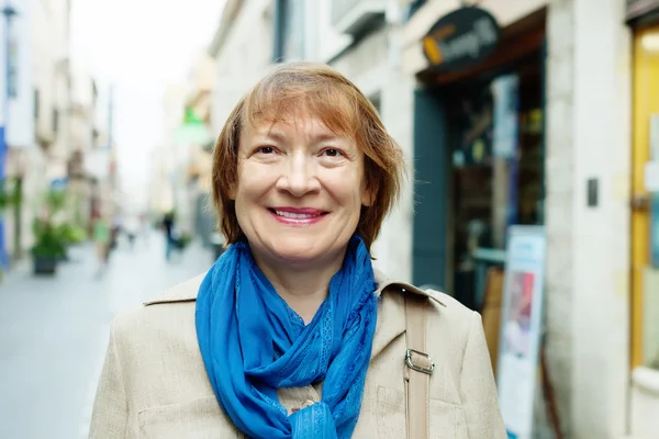 Smiling mature woman in city street — Stock Photo, Image