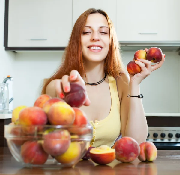 Kobieta z brzoskwiń w domu kuchnia — Zdjęcie stockowe