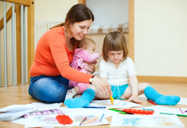 Счастливая мать и ее дети рисуют на бумаге — стоковое фото