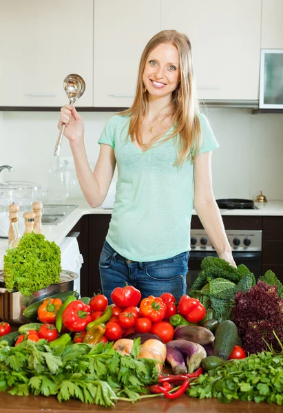 Beautiful woman cooking with ladle from vegetables — Stock Photo, Image
