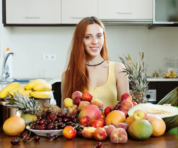 Chica positiva con montón de frutas — Foto de Stock