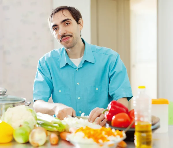 Homem com legumes na cozinha doméstica — Fotografia de Stock