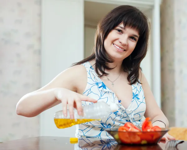 Femme verser de l'huile à la salade à la maison — Photo