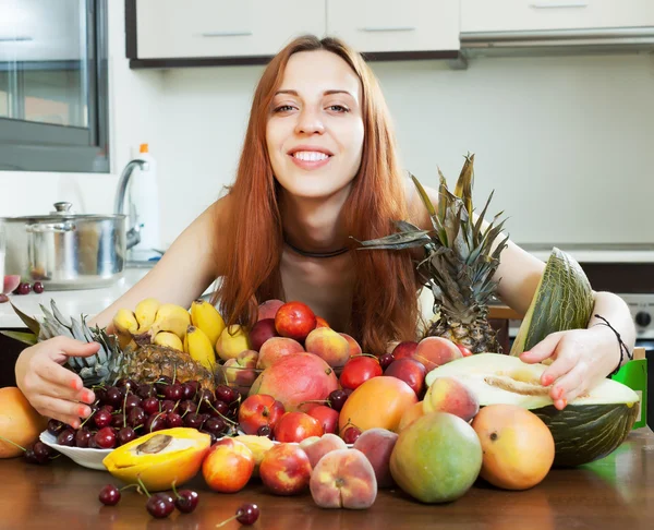 Счастливая девушка с кучей фруктов — стоковое фото